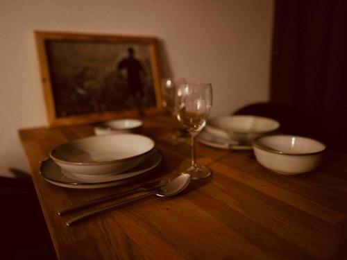 einem Holztisch mit Tellern und einem Glas Wein in der Unterkunft stilvolles und komfortables Chalet mit Weitblick in Ebenfeld