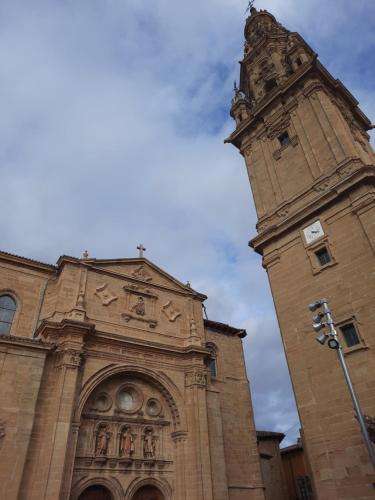 a tall building with a tower and a clock at Villa- Belen in Santo Domingo de la Calzada