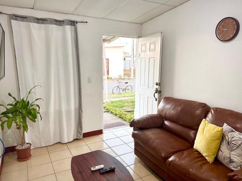 a living room with a brown leather couch and a table at Casa Valle Verde in Managua