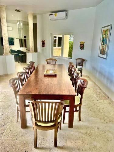 a dining room with a large wooden table and chairs at NewVilla-Coral Estate-WalktoBeach-Private Pool-up to 16 Guests SeaView in Willibrordus
