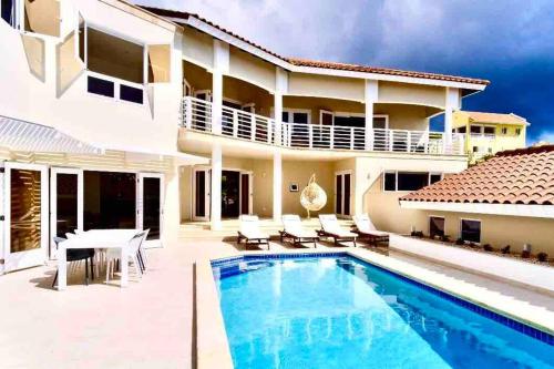 a villa with a swimming pool and a house at NewVilla-Coral Estate-WalktoBeach-Private Pool-up to 16 Guests SeaView in Willibrordus