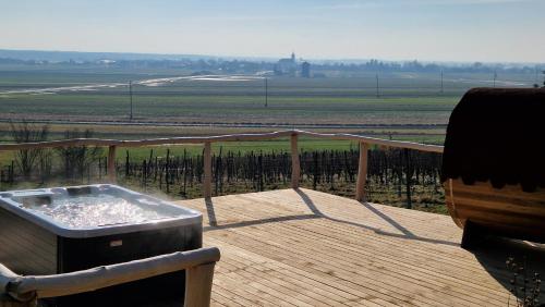 a hot tub on a deck with a view of a field at Holiday House Clavis in Dobrovnik