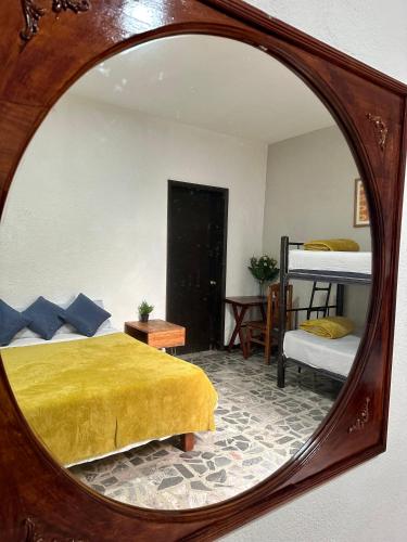 un miroir reflétant une chambre avec un lit et des lits superposés dans l'établissement Hostel Xitla, à Oaxaca
