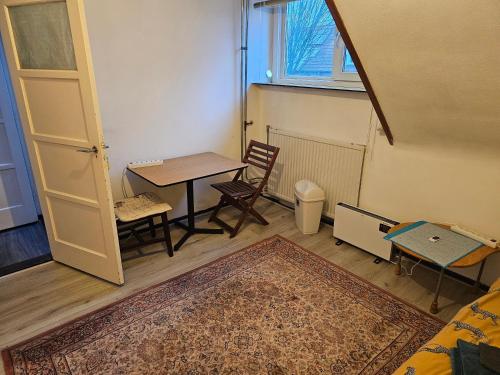 a room with a table and chairs and a door at Single bed in quiet area in Eindhoven