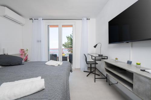 um quarto com uma cama, uma secretária e uma televisão em Luxury Seaview Apartment em Juraši