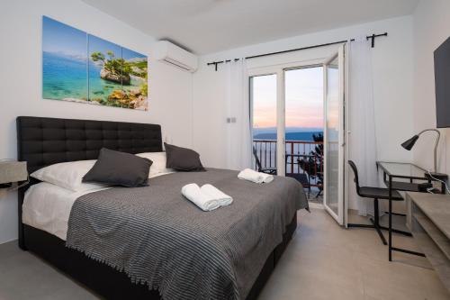Schlafzimmer mit einem Bett und einem Tisch sowie einem Balkon in der Unterkunft Luxury Seaview Apartment in Juraši