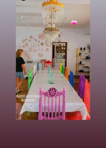 a dining room with a table with a pink chair at Guesthouse Gate5 in Anadia
