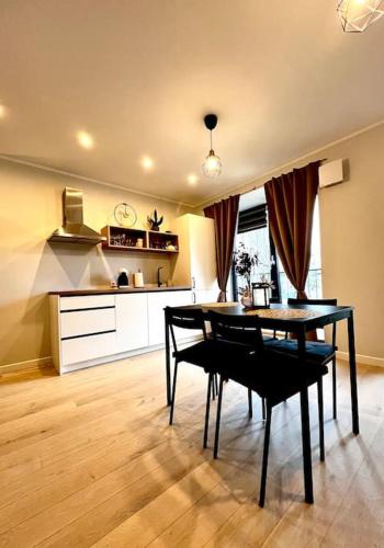 a kitchen with a table and a dining room at Seashell Albatross Boutique Apartment in Ķesterciems