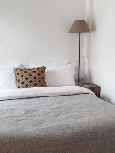 a bedroom with a bed with white sheets and a lamp at Riad Atay in Marrakech