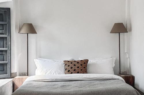 a bedroom with a bed with two lamps at Riad Atay in Marrakesh