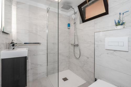 uma casa de banho com um chuveiro, um WC e um lavatório. em Luxury Seaview Apartment em Juraši