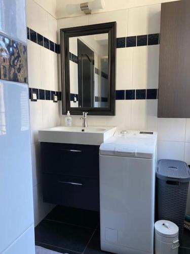 une salle de bain avec un lavabo et un miroir dans l'établissement Moderne - WIFI - Plage à pied - Marché provençal, à Toulon