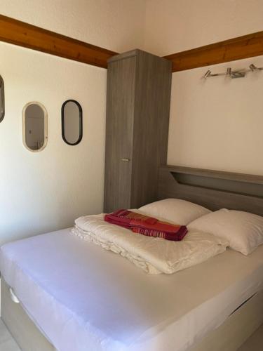 - un lit avec un livre rouge au-dessus dans l'établissement Superbe maisonnette au pied de la plage à Bidart 64, à Bidart