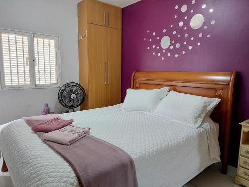 1 dormitorio con 1 cama grande y paredes moradas en Ideal para família e grupos, local nota 10 e Wi-fi top!, en Brasilia