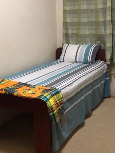 Una cama con una manta encima. en Room in Guest room - Logerthine Cambridge Suriname en Paramaribo