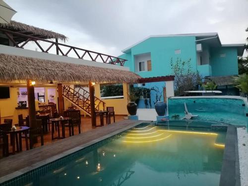 a villa with a swimming pool and a restaurant at Island Luxury Dive Hotel - Fulhadhoo in Fulhadhoo