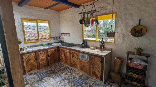- une cuisine avec des placards en bois et des fenêtres dans la chambre dans l'établissement Charming Coffee Farm House, à Salento