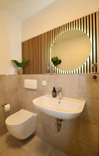 Un baño con lavabo, inodoro y espejo. en Zentrales hochwertiges Gründerzeit-Apartment Thomasius, en Leipzig