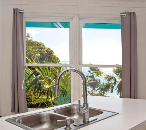 a kitchen sink in front of a window at OceanBliss: Exuma, Waterfront sleeps 8 in Michelson