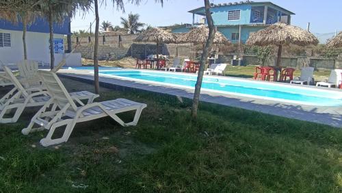 a group of chairs and a swimming pool at Hotel La Intimidad in Antón Lizardo