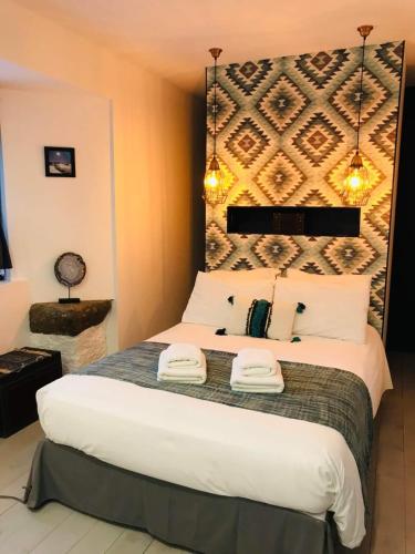 a bedroom with a large bed with two towels on it at Les cailloux in Saint-Urcize