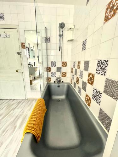 a bath tub in a bathroom with a yellow towel at Gîte de la Cigale in Burzet