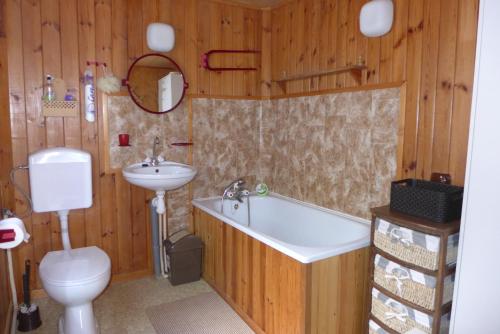 a bathroom with a toilet and a tub and a sink at Lake House Narty in Narty