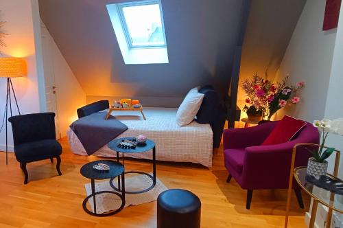 - un salon avec un lit et deux chaises dans l'établissement Appartement F2 idéalement situé, à Caen