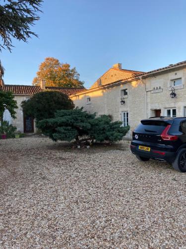a car parked in front of a house with christmas trees at Hotel Karina in Jarnac