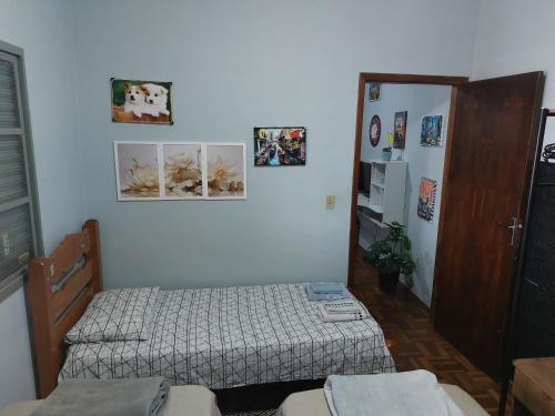 a bedroom with two beds and a door with pictures on the wall at Ecohouse - Próx da Av Brasil in Franca