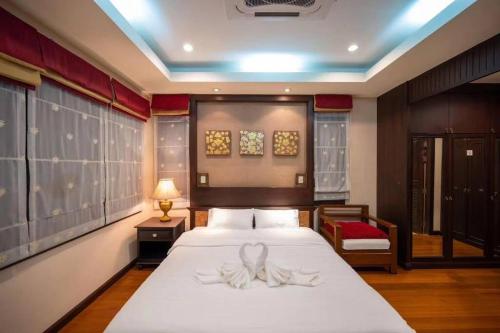 a bedroom with a large bed with white sheets at 芭提雅市中心三臥室泳池別墅(可燒烤) in Pattaya Central