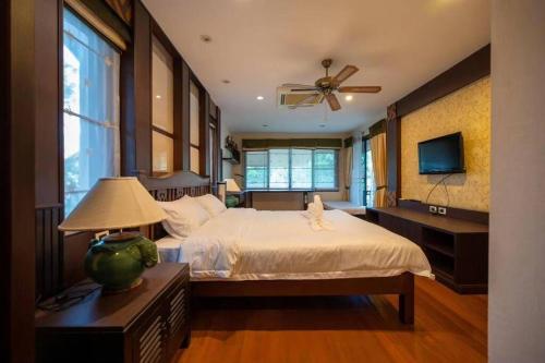 a bedroom with a bed and a ceiling fan at 芭提雅市中心三臥室泳池別墅(可燒烤) in Pattaya Central