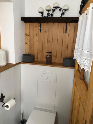 a bathroom with a toilet and a wooden wall at Fachwerk Ferienhaus Elz in Elz