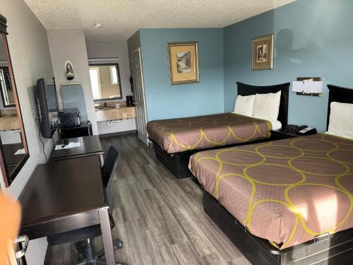 a hotel room with two beds and a desk at Kansas Inn in Independence