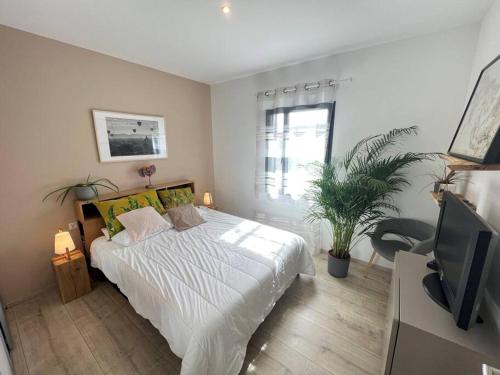 une chambre avec un lit blanc et une télévision dans l'établissement 3 bedrooms new house with heated swimming pool, à Carpentras