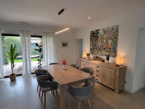 une salle à manger avec une table et des chaises en bois dans l'établissement 3 bedrooms new house with heated swimming pool, à Carpentras