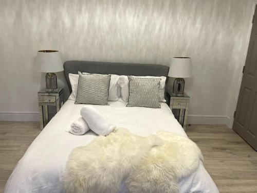 uma cama branca com almofadas e um cobertor em Stylish King Size Room in Modern Renovated House em Catford