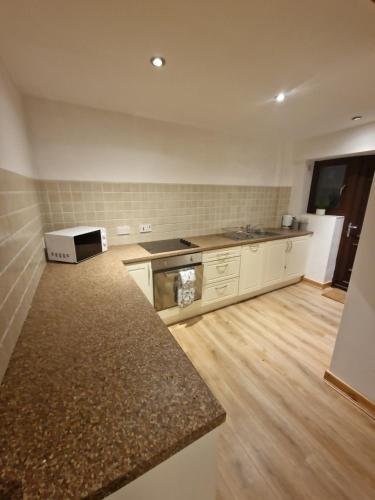 a kitchen with a stove and a counter top at the lodge@ beechwood house in Mossley