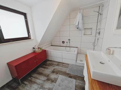 a bathroom with a white tub and a sink at CASA Chic - Zentral - Balkon - Parkplatz - SmartTV - Unique - Kernen in Stetten