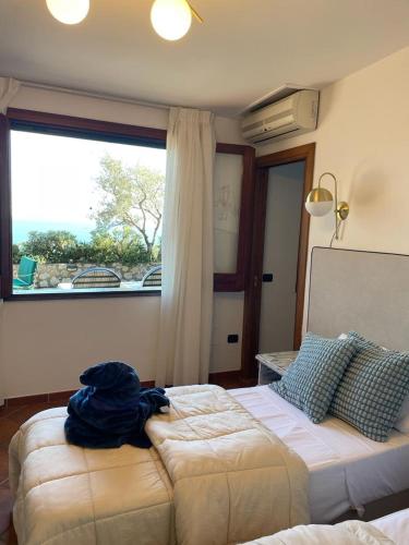 a bedroom with a bed and a large window at Seacliff Heaven - De Vivo Realty Positano in Arola