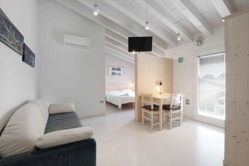 een witte woonkamer met een bank en een tafel bij Residence Gonda&Giuliano in Borso del Grappa