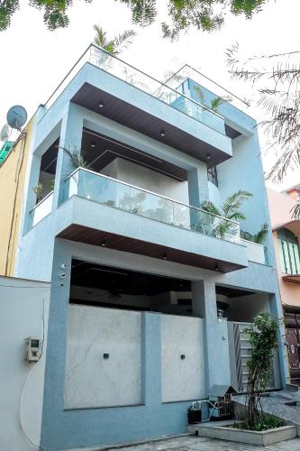a blue house with a balcony in front of it at Anirudh Homestay in Agra