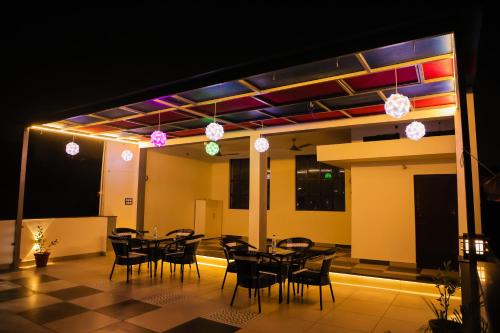 a room with a table and chairs and lights at Anirudh Homestay in Agra