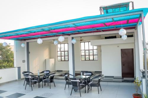 a patio with tables and chairs in a building at Anirudh Homestay in Agra