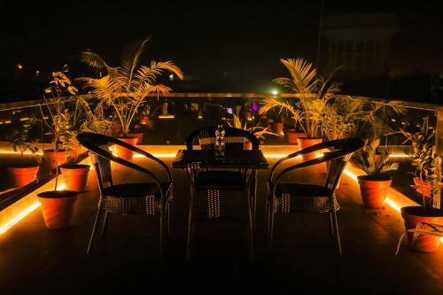a table and chairs on a balcony at night at Anirudh Homestay in Agra