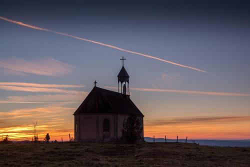 a church with a cross on top of a hill at Boutique Hôtel - Notre Chalet in Les Fourgs