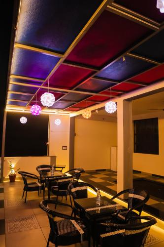 a dining room with tables and chairs and lights at Anirudh Homestay in Agra