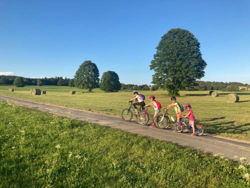 a group of people riding bikes down a dirt road at Boutique Hôtel - Notre Chalet in Les Fourgs