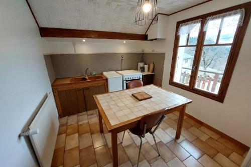a small kitchen with a table and a sink at Sous l'Alpette en Chartreuse in Saint-Pierre-dʼEntremont