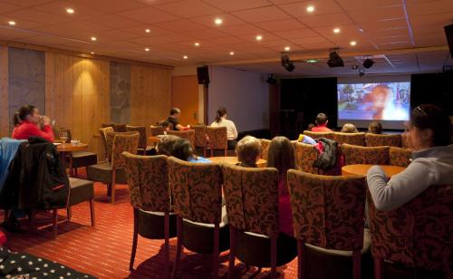 a group of people sitting at tables in a room at Hôtel Club mmv Les Mélèzes **** in Arc 2000
